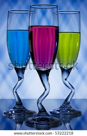 Blue, pink, and green, liqueur glasses on blue and white background