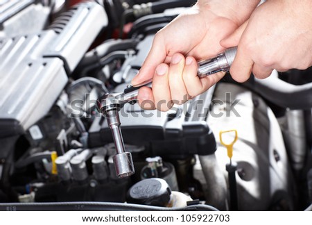 Hand of auto mechanic with a wrench. Car repair.