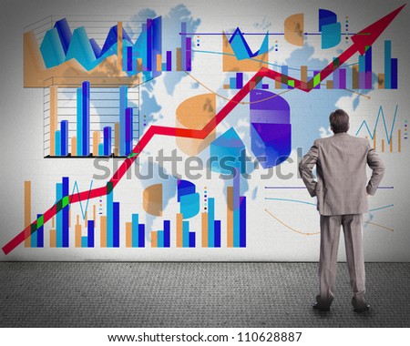 Businessman looking at the board with graphs.