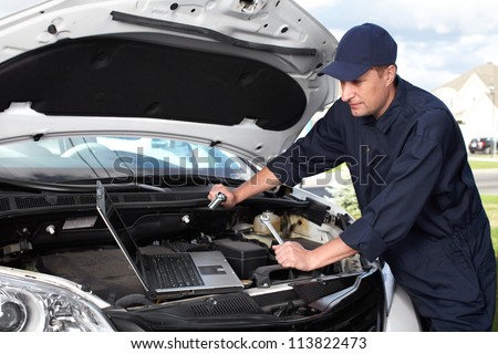 Car mechanic working in auto repair shop.