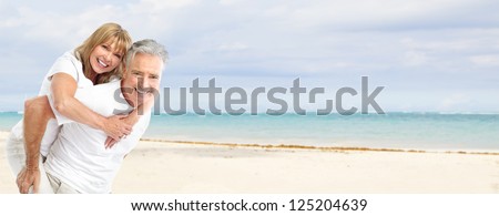 Happy Senior Couple On The Beach. Exotic Luxury Resort.