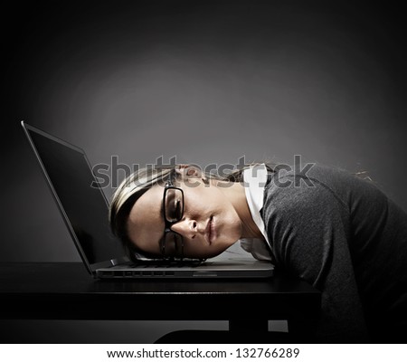 Tired woman student sleeping on laptop computer.
