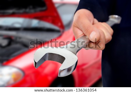 Hand with wrench. Auto mechanic in car repair .