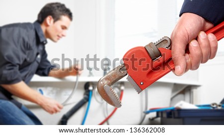 Hand with wrench. Plumber. Plumbing service concept.
