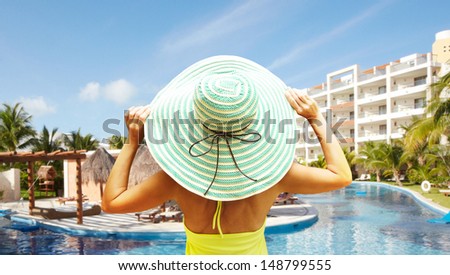 Woman in the hat on vacation. Tropical resort.