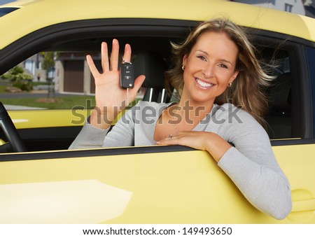 Young beautiful woman car driver in a new auto.