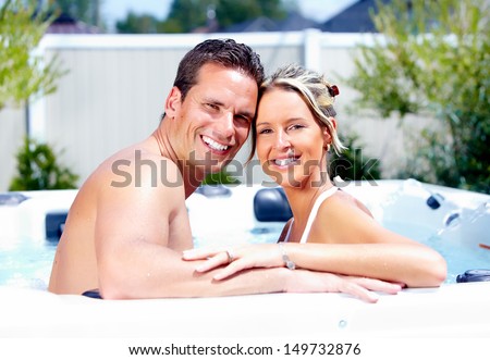 Happy couple relaxing in hot tub. Vacation.