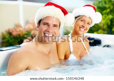 Happy christmas santa couple in hot tub. Vacation.