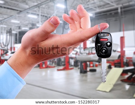 Hand with a car keys in auto repair service.