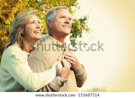 Happy Senior Couple Relaxing In The Park.