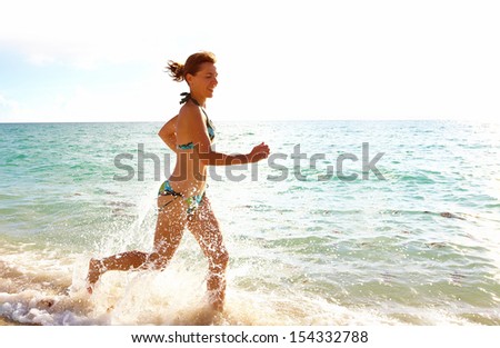 Woman running on Miami beach. Vacation.