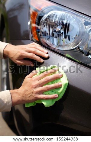 Hand with microfiber cloth cleaning car Hand with microfiber cloth cleaning car
