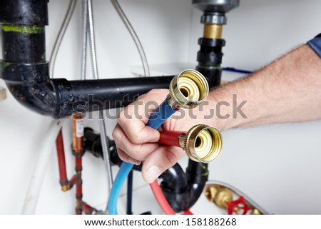 Hands of professional Plumber with a wrench. Clogged sink.
