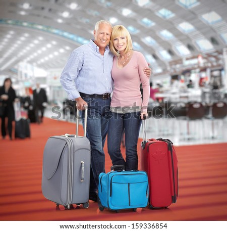 Senior couple in airport. Holiday travel background.