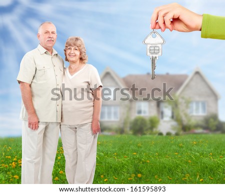 Senior couple near new home. Real estate background.