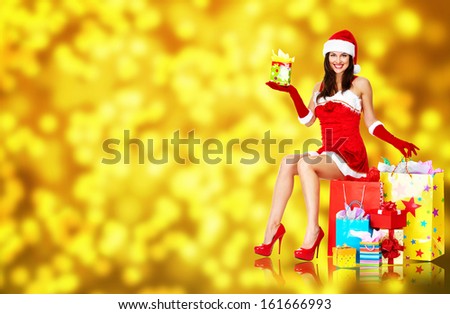 Beautiful Girl with Christmas gifts over Xmas background.