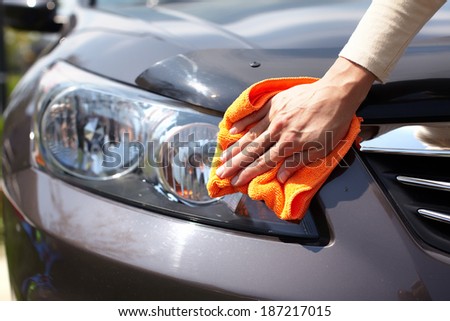 Hand with microfiber cloth cleaning car Hand with microfiber cloth cleaning car