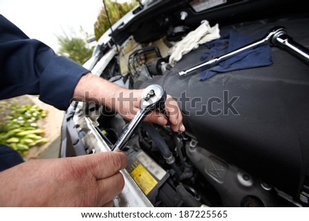 Hands of auto mechanic with wrench. Car repair service.