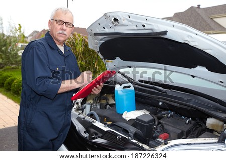 Auto mechanic checking engine. Car repair service.