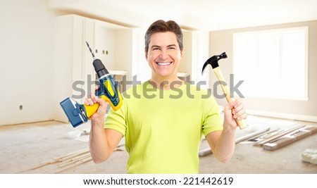 Man with hammer and drill. House renovation and construction.