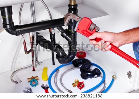 Plumber hands with a wrench. Plumbing renovation background.