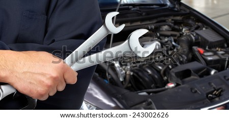 Hand of mechanic with wrench. Car repair garage.