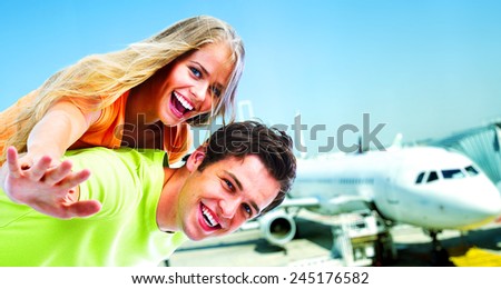 Happy young loving couple having fun near plane.