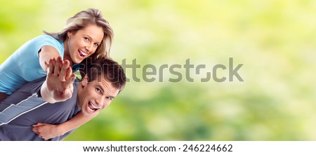 Young happy loving couple over green summer background