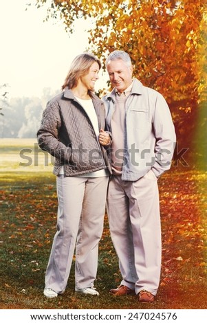 Happy senior loving couple over park nature background