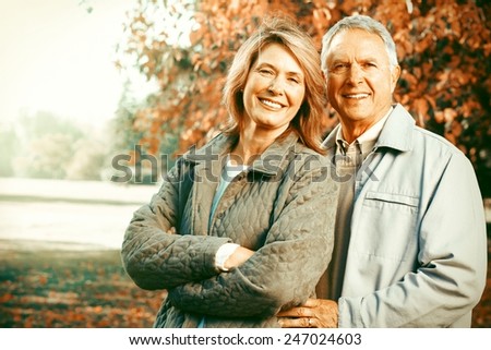 Happy senior loving couple over park nature background
