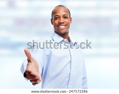 Handshake. African-American businessman over blue office background