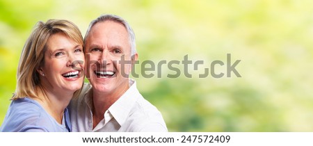 Happy senior loving couple over green nature background