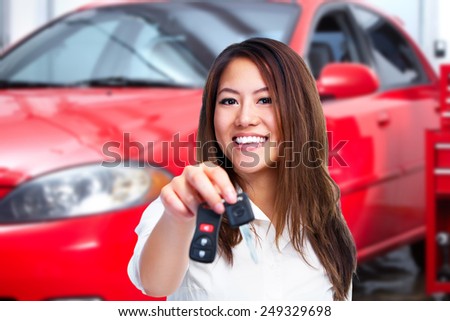 Woman holding a car key. Auto repair service