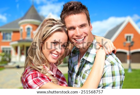 Happy Couple near new house. Real estate background.