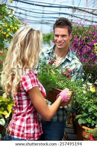 Gardening people. Couple working in greenhouse with flowers.