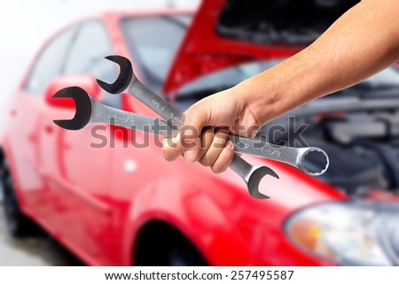 Hand of car mechanic with wrench. Auto repair garage.