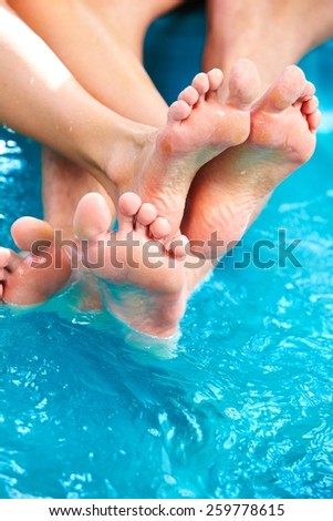 People feet relaxing in hot tub. Summer vacation.