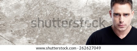 Handsome young man portrait over vintage wall background.