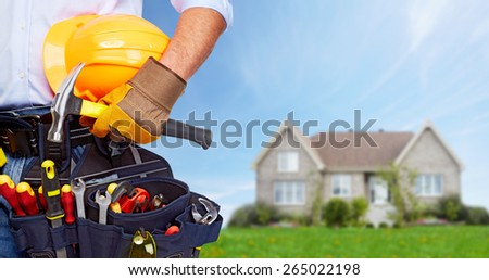 Builder handyman with construction tools. House renovation background.