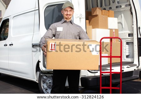 Young delivery man with parcel near cargo truck. Shipping service.