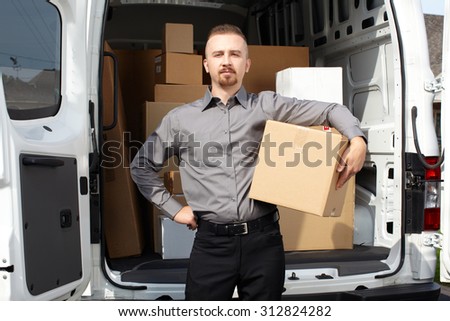Young postman with parcel near delivery truck. Shipping service.