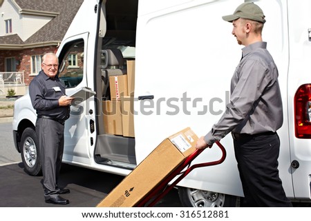 Group of delivery men with parcels near shipping truck. Parcel service.