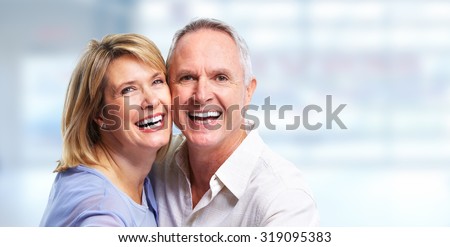 Happy senior couple portrait over blue background.