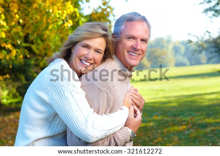 Happy senior couple in park. Autumn and fall background.