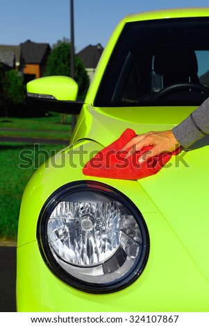 Hand with cloth washing a car. Waxing and polishing.