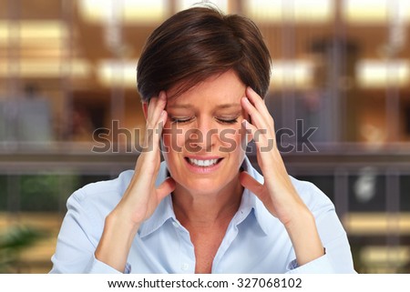 Tired business woman with headache migraine over house background
