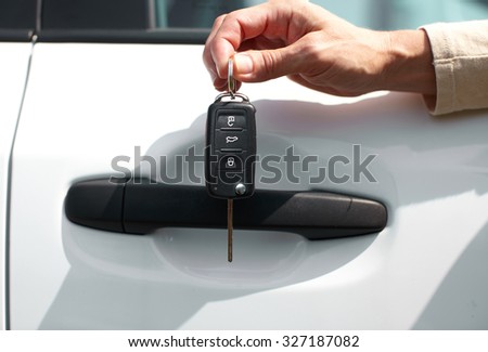 Hand of driver with a car key. Auto rent and sell.