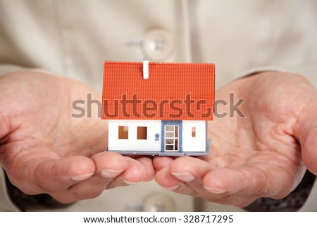 Hands with little house. Real estate and construction background.