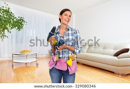 Young woman with a drill. House renovation background.