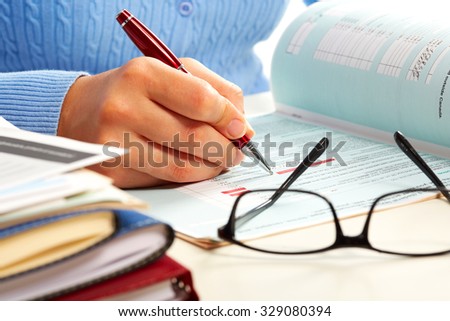 Hand with a pen writing. Accounting and finance background.
